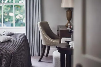 a bedroom with a bed and a desk and a chair at Marquis Suffolk in Ipswich