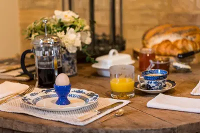 a wooden table with an egg and a plate of food at Cambridge Country Cottages in Cambridge