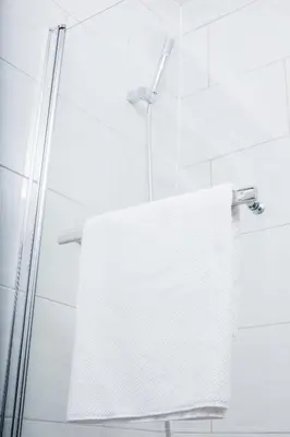 a white towel hanging from a shower door at Wherstead House in Ipswich