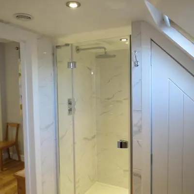 a shower with a glass door in a bathroom at Maltings Loft in Hepworth