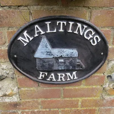 a sign for a farm on a brick wall at Maltings Loft in Hepworth