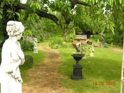 a statue of a woman standing in a garden at Frasers in Battlesbridge