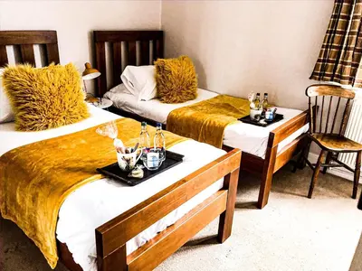 a room with two beds and a table and chairs at Frasers in Battlesbridge