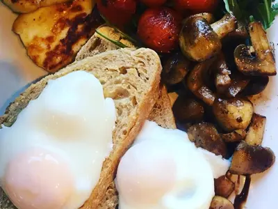 a plate of food with an egg and bread and mushrooms at Frasers in Battlesbridge