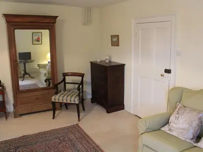 a living room with a couch and a chair and a mirror at Church Farmhouse B & B in Kennett