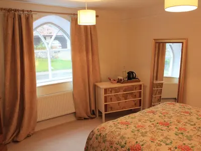 a bedroom with a bed and a window and a dresser at Church Farmhouse B & B in Kennett