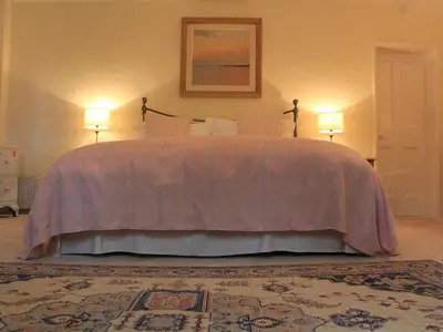 a bedroom with a large bed with two lamps at Church Farmhouse B & B in Kennett