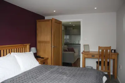 a bedroom with a bed and a desk and a chair at Amberleigh House Annex in Newmarket