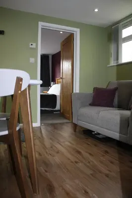a living room with a couch and a bed at Amberleigh House Annex in Newmarket
