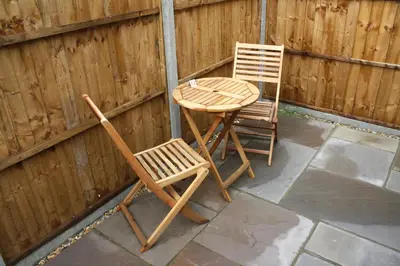 a table and two chairs sitting next to a fence at Amberleigh House Annex in Newmarket