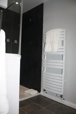 a towel rack in the corner of a bathroom at Amberleigh House Annex in Newmarket
