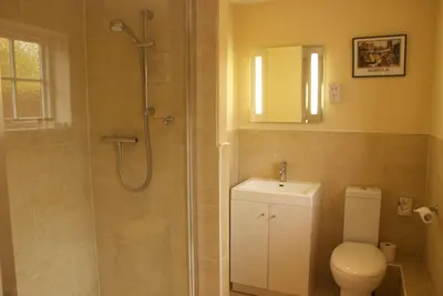 a bathroom with a shower and a toilet and a sink at Chantry Hotel in Bury Saint Edmunds