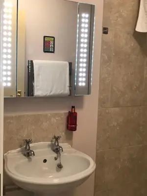 a bathroom with a sink and a mirror at The Old School House Rooms in Waterbeach