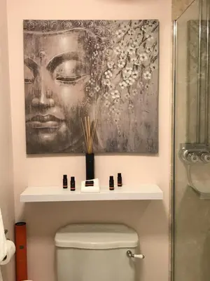 a bathroom with a painting above a toilet at The Old School House Rooms in Waterbeach