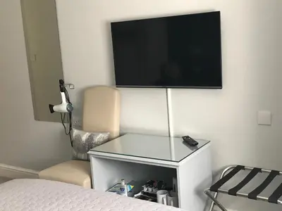 a bedroom with a bed and a television on a wall at The Old School House Rooms in Waterbeach