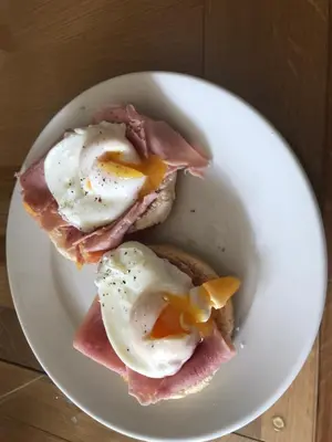 a plate of food with eggs and bacon on a table at The Old School House Rooms in Waterbeach
