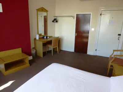 a room with a bed and a desk and a mirror at Esplanade Hotel - Clacton On Sea, Beachfront Hotel by OYO in Clacton-on-Sea