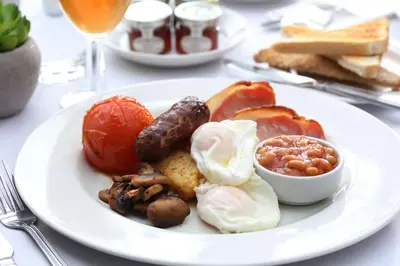 a plate of breakfast food with eggs sausage and beans at Best Western Claydon Hotel in Ipswich