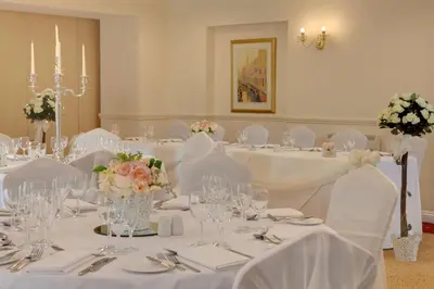 a room with white tables with white chairs and flowers at Best Western Claydon Hotel in Ipswich