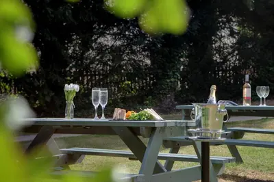 a picnic table with wine glasses and food on it at Best Western Claydon Hotel in Ipswich