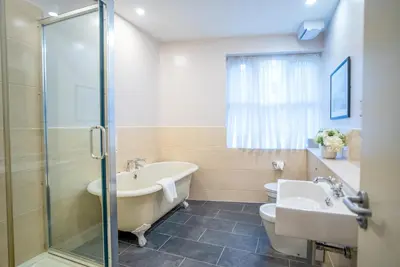 a bathroom with a tub and a toilet and a sink at County Hotel in Chelmsford