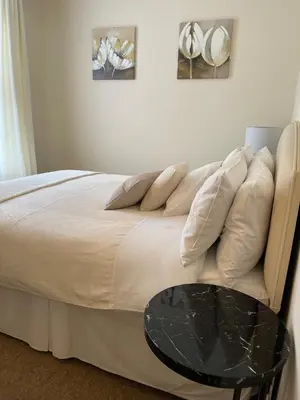 a bedroom with a bed with a black table at CARIS Guest House in Southend-on-Sea