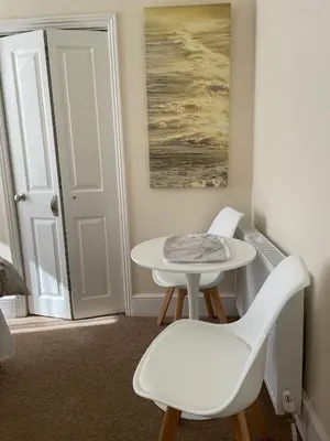 a white table and chairs in a room with a door at CARIS Guest House in Southend-on-Sea