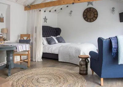 a bedroom with a bed and a desk and a chair at Crafts Hill Barn in Cambridge