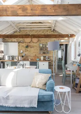 a living room with a blue couch and a brick wall at Crafts Hill Barn in Cambridge