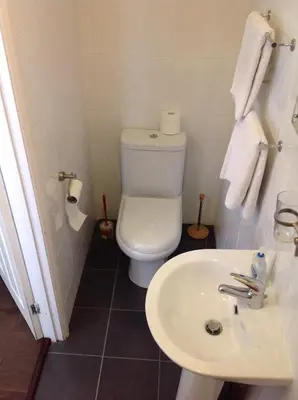 a bathroom with a white toilet and a sink at Repton Private Hotel in Romford