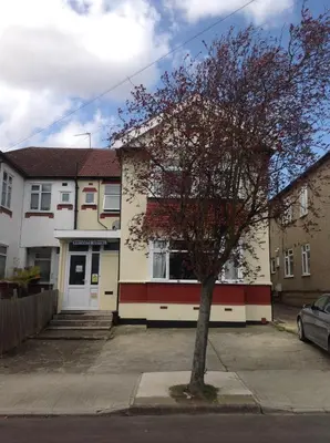 a house with a tree in front of it at Repton Private Hotel in Romford
