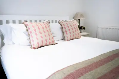 a white bed with two pillows on top of it at The Three Hills in Bartlow