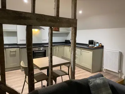 a kitchen with a table and chairs in a room at The Three Hills in Bartlow