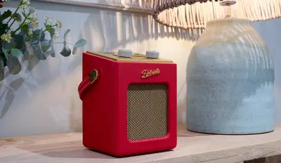 a red radio sitting on a table next to a vase at The Three Hills in Bartlow