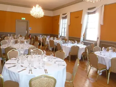 a room with tables and chairs with white tablecloths at Old Bull Inn in Royston