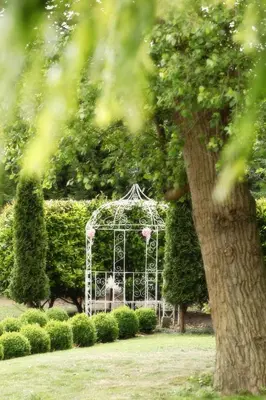 a white gate in a garden with a tree at Cambridge Quy Mill Hotel & Spa in Cambridge