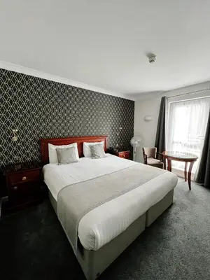 a bedroom with a large bed in a room at Manor Of Groves Hotel, Golf & Health Club in Sawbridgeworth