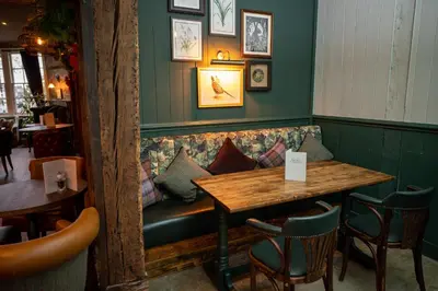 a restaurant with a couch and a table and chairs at Green Man by Chef & Brewer Collection in Harlow