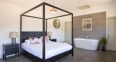 a bedroom with a canopy bed and a bath tub at Clopton Courtyard Cambridge in Cambridge