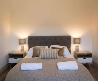 a bedroom with a large bed with two night stands at Clopton Courtyard Cambridge in Cambridge