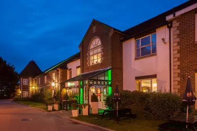 a row of houses with green lights on a street at Holiday Inn Ipswich Orwell by IHG in Ipswich