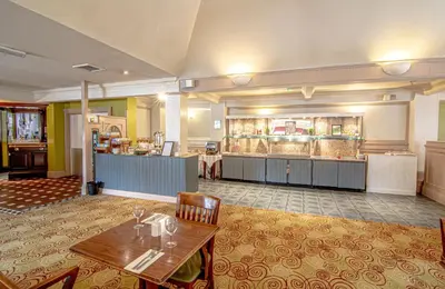 a restaurant with a table and chairs in a room at Holiday Inn Ipswich Orwell by IHG in Ipswich