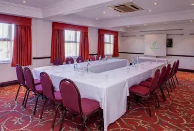 a conference room with a long table and chairs at Holiday Inn Ipswich Orwell by IHG in Ipswich