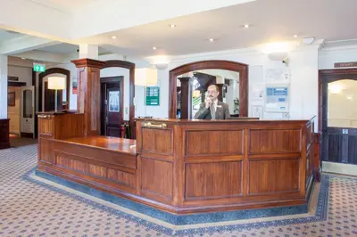 a man is sitting at a bench in a courtroom at Holiday Inn Ipswich Orwell by IHG in Ipswich