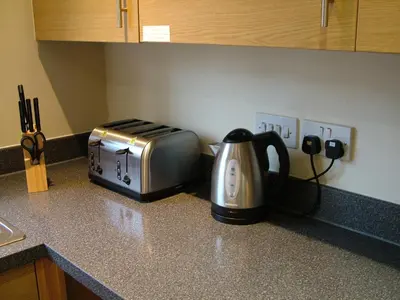 a kitchen counter with a toaster and a tea kettle at Thistle Cottage in Mildenhall