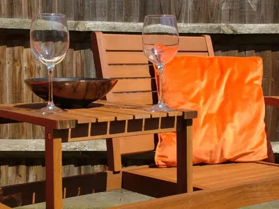 two wine glasses sitting on a wooden table at Thistle Cottage in Mildenhall
