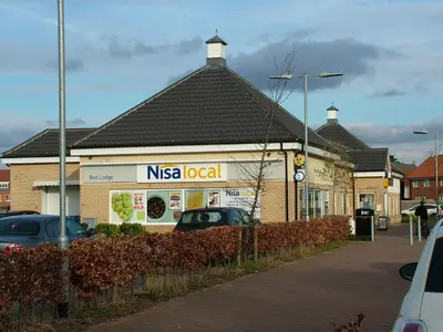 a nissocial store with cars parked in front of it at Thistle Cottage in Mildenhall