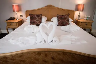 a bed with white towels and pillows on it at The Saracens Head Hotel - The Coaching Inn Group in Great Dunmow