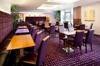a dining room with wooden tables and chairs at Holiday Inn Express Cambridge by IHG in Cambridge