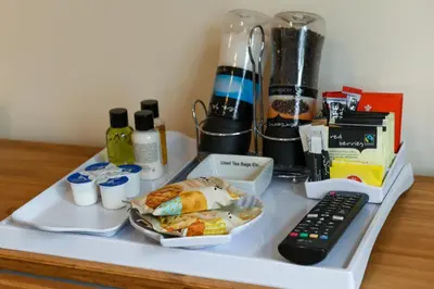 a tray with a plate of food and a remote control at Fennec Apartments in Cherry Hinton
